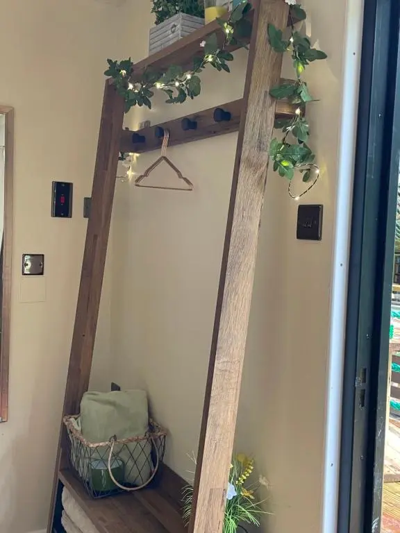 a ladder shelf in the corner of a room with plants at The Cabin, Stronua. A beautiful 1 bedroom cabin. in Fort Augustus