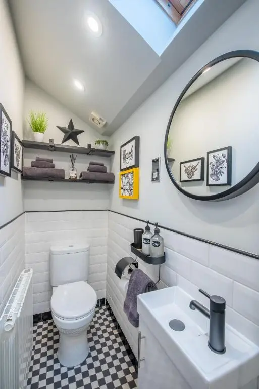 a bathroom with a white toilet and a mirror at Crossroads Cottage in Drumnadrochit