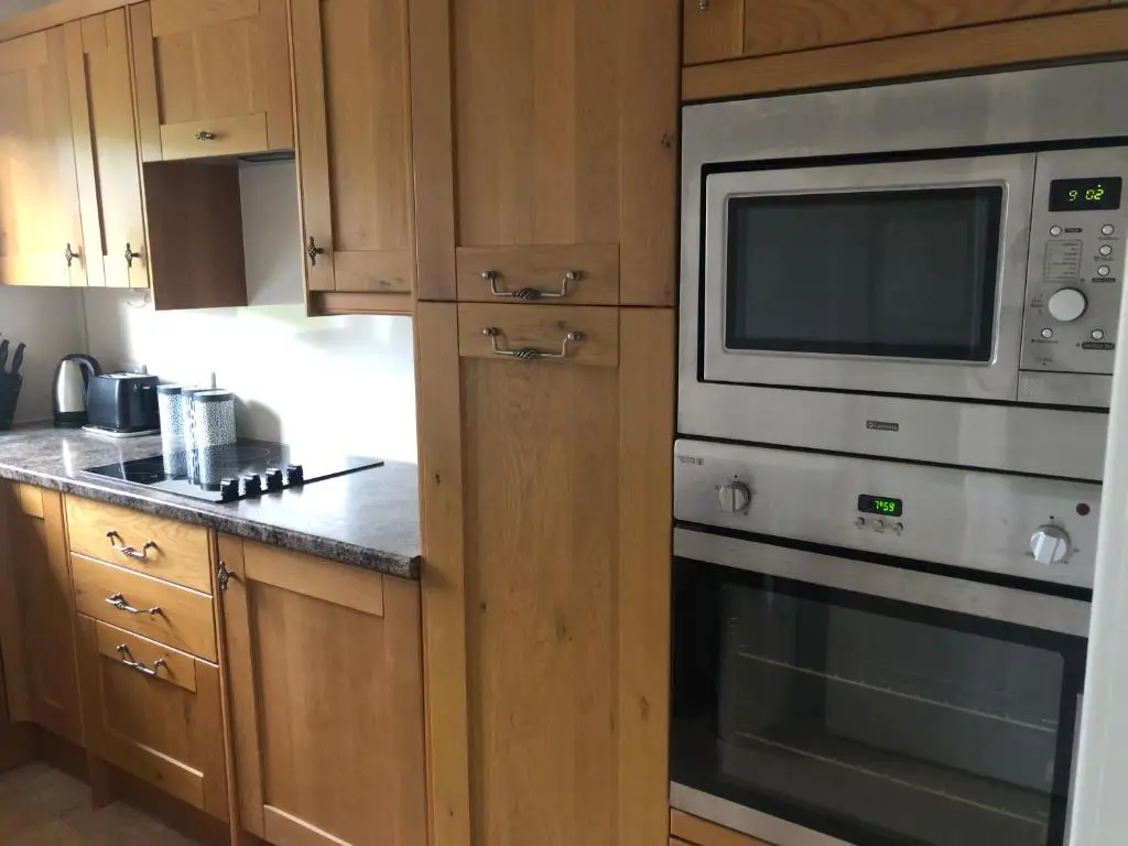 a kitchen with a stove and a microwave at River Ness View in Inverness