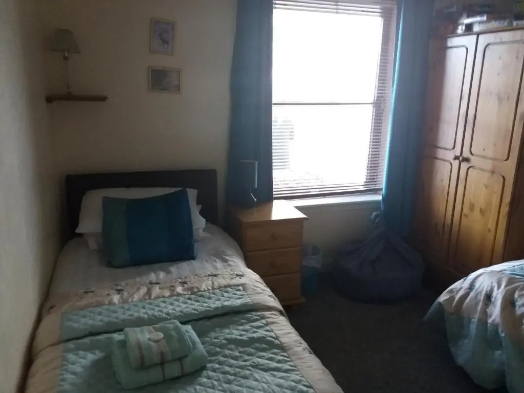a small bedroom with a bed and a window at Aviemore Glenlivet Lodge in Aviemore