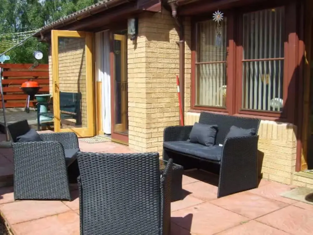 a patio with wicker chairs and a couch at Aviemore Glenlivet Lodge in Aviemore