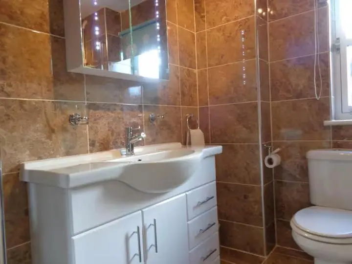 a bathroom with a sink and a toilet and a mirror at Aviemore Glenlivet Lodge in Aviemore