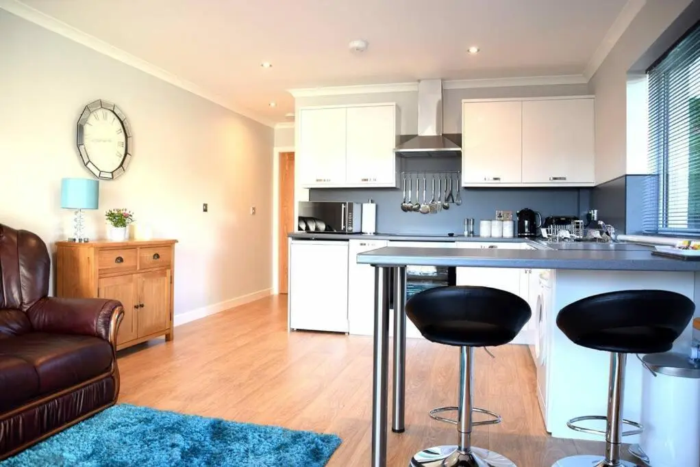a kitchen with a counter and two bar stools at Rammal Lodge - Entire home, self catering apartment in Inverness in Inverness