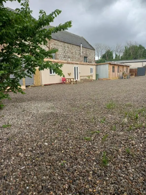 a large gravel driveway with a building in the background at Half Pint in Tain