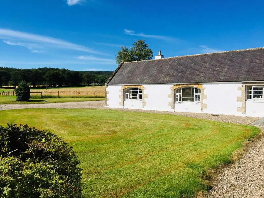 an old white cottage with a large yard at Bruntlands Steading in Fochabers