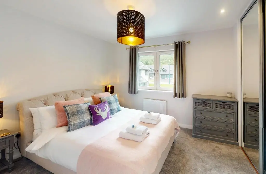 a bedroom with a large bed and a window at 10 Bynack House in Aviemore