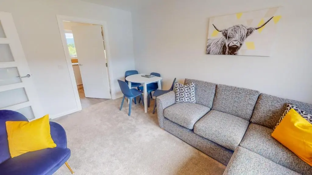 a living room with a couch and a table at 10 Bynack House in Aviemore
