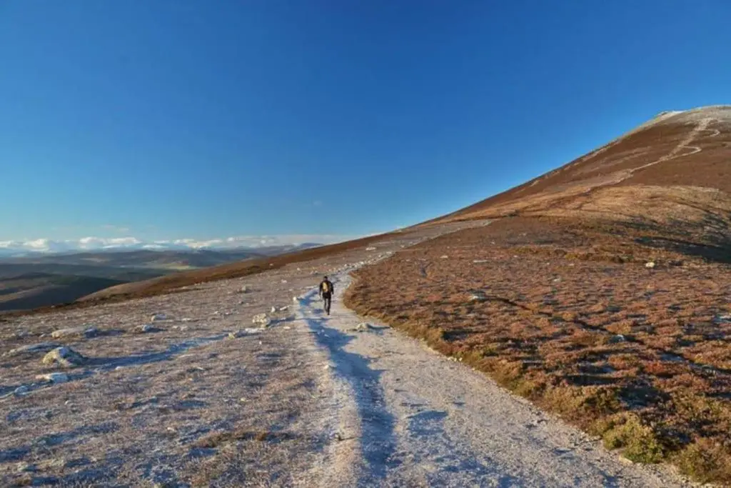 a person walking down a dirt road on a hill at Garbity Cottage in Fochabers
