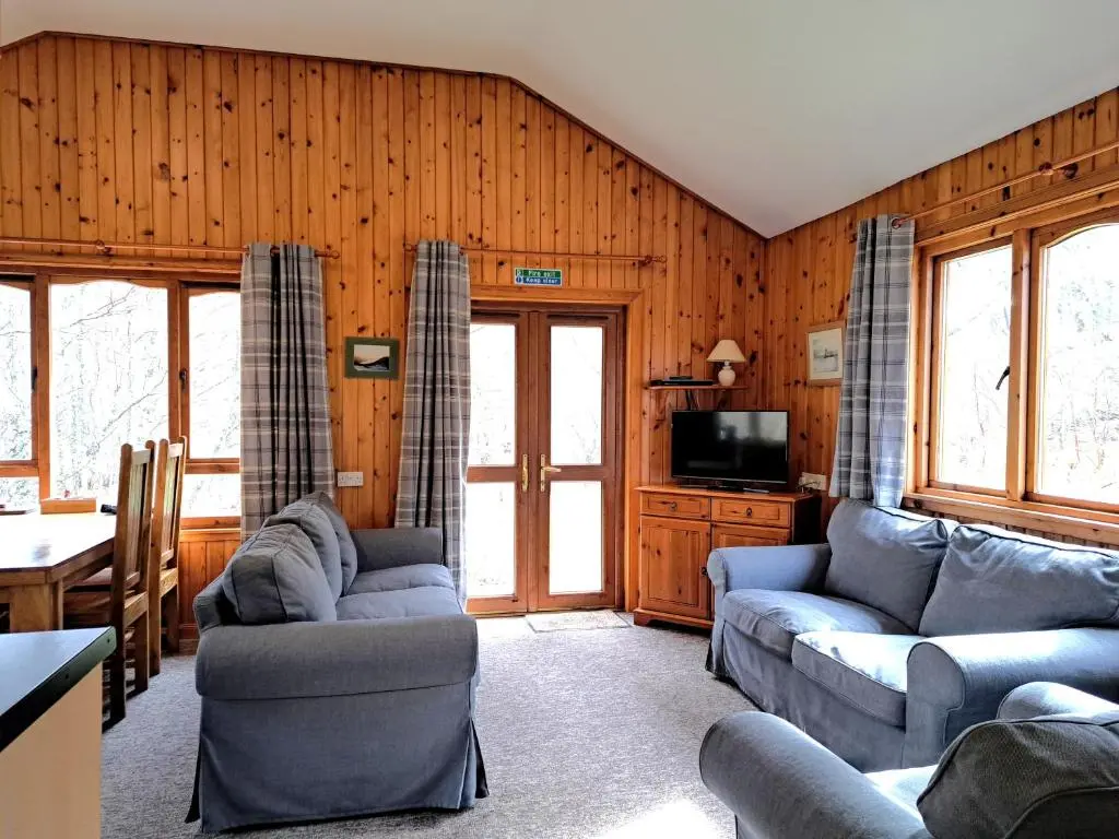 a living room with two couches and a tv at Plodda Lodge at Lochletter Lodges in Drumnadrochit