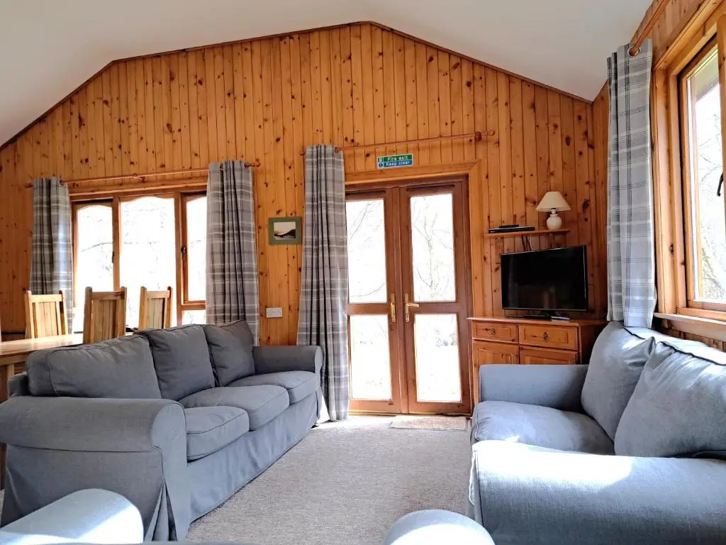a living room with two couches and a tv at Plodda Lodge at Lochletter Lodges in Drumnadrochit