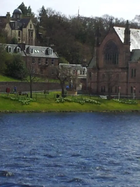 a building next to a body of water at Ness View Apartment in Inverness