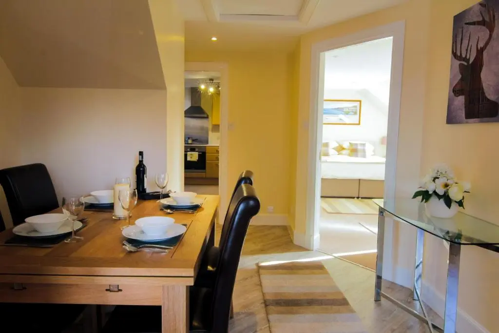 a dining room with a wooden table and a dining room at Ness View Apartment in Inverness
