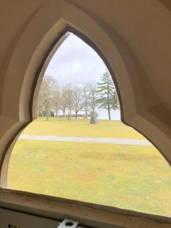 an arched window with a view of a park at 3 BR Luxury Apt at Highland Club - Fort Augustus in Fort Augustus