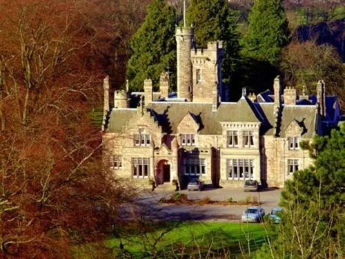 a large stone house with a tower on top of it at Mansion House Hotel in Elgin