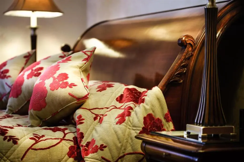 a close up of a chair with pillows and a lamp at Mansion House Hotel in Elgin
