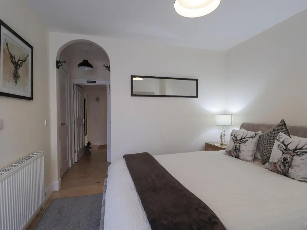a bedroom with a large bed and a hallway at Ballinreich in Inverness