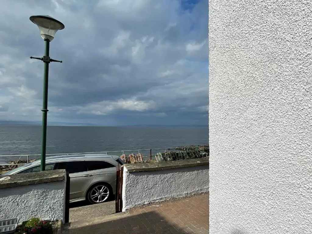 a car parked next to a street light next to the ocean at Harbour Street in Portmahomack