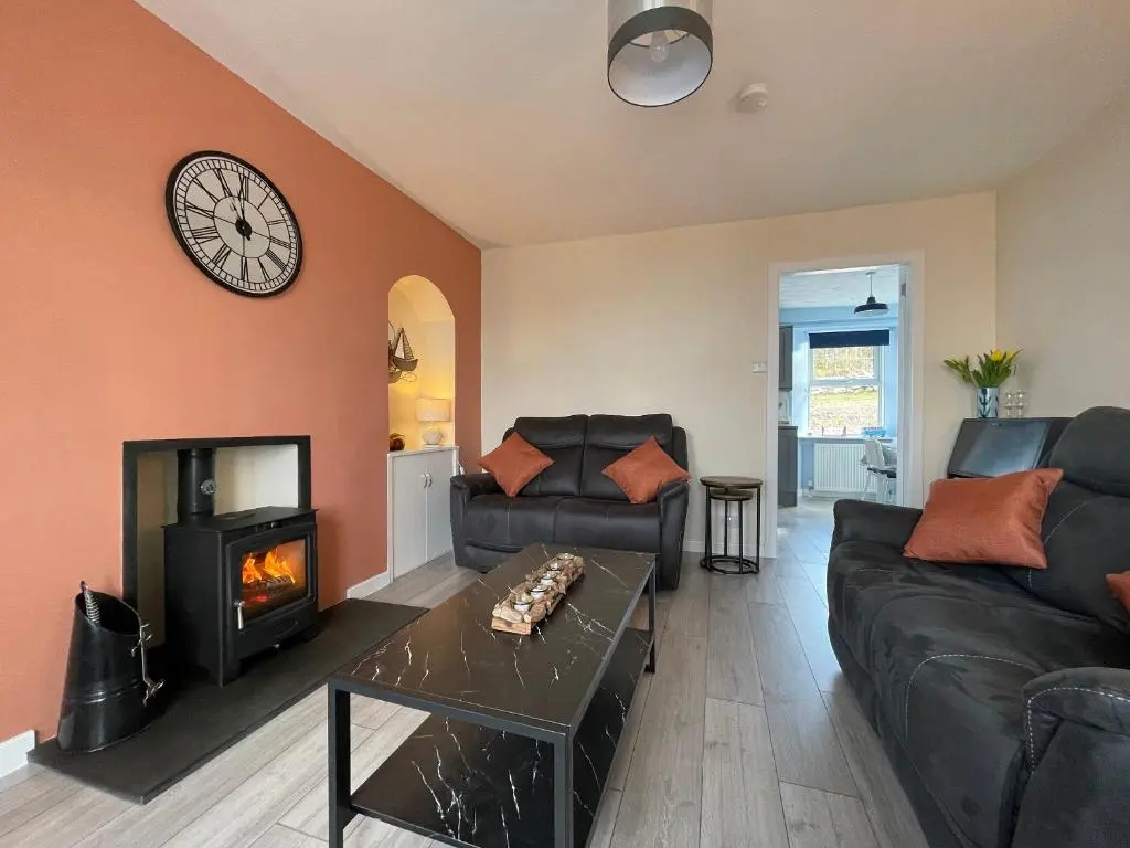 a living room with a couch and a fireplace at Harbour Street in Portmahomack