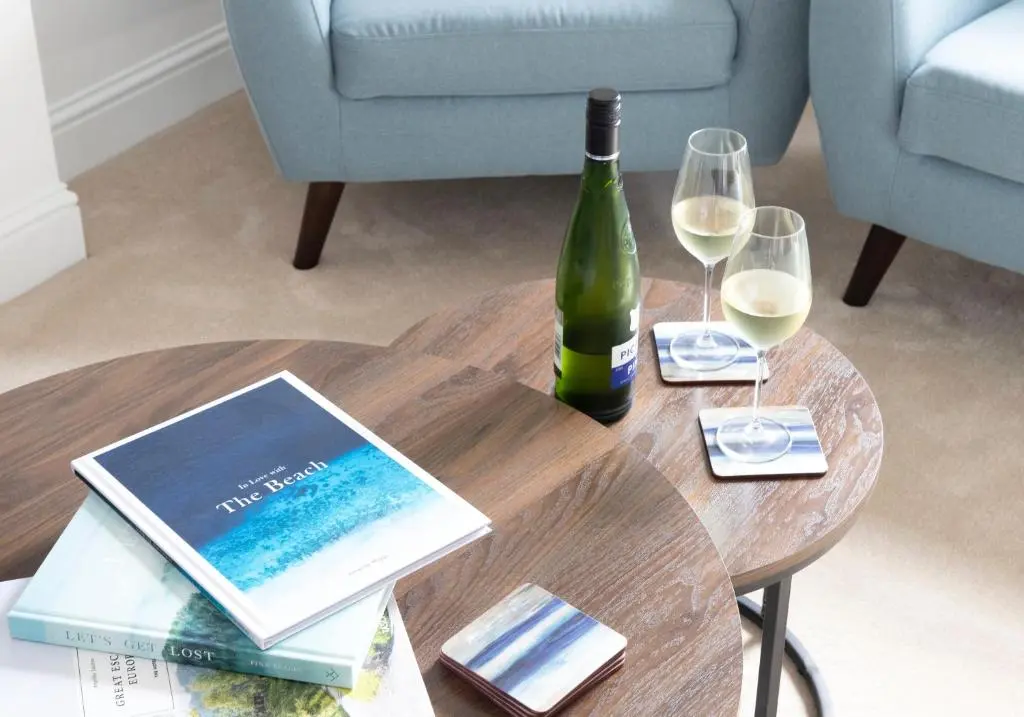 a table with a bottle of wine and two glasses at Aurora House Hot Tub & Sea View in Buckie