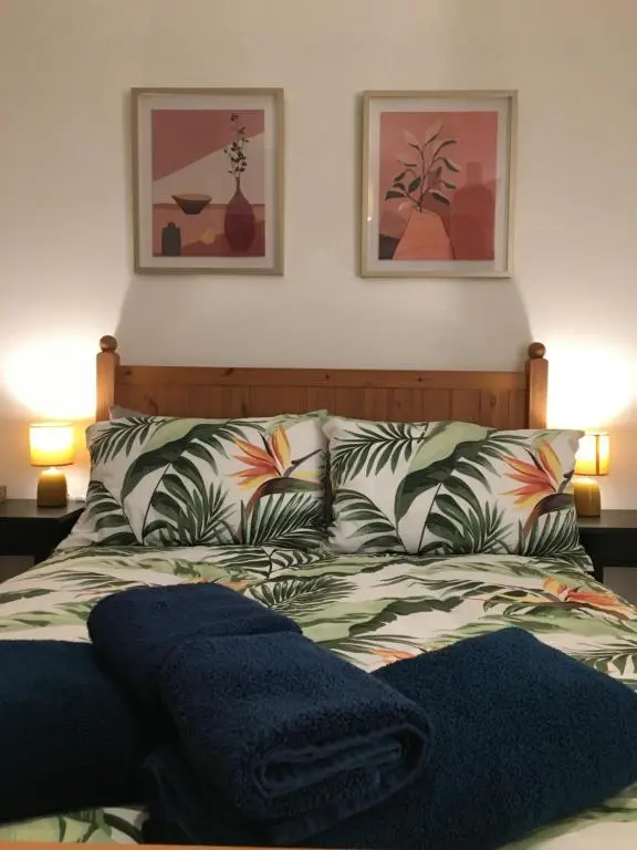 a bedroom with a bed with two pictures on the wall at Columba House in Inverness