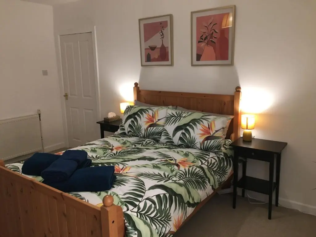 a bedroom with a bed with a bedspread with palm leaves at Columba House in Inverness