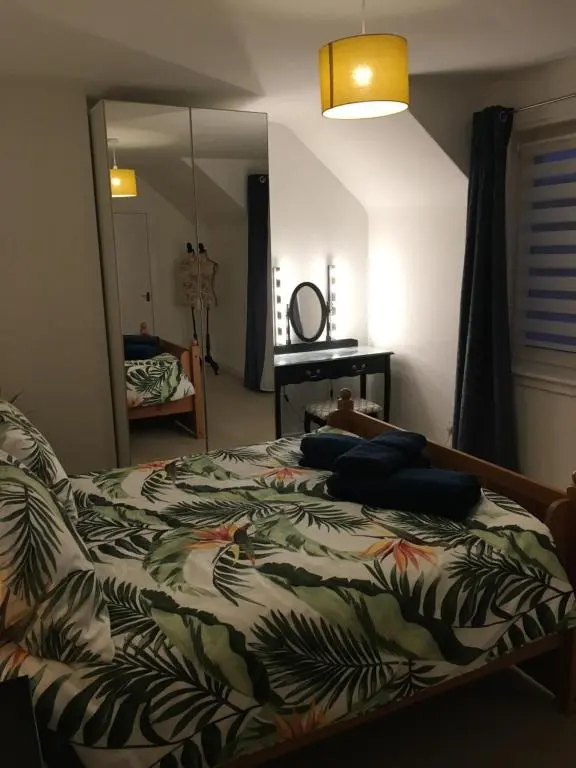 a bedroom with a bed and a large mirror at Columba House in Inverness