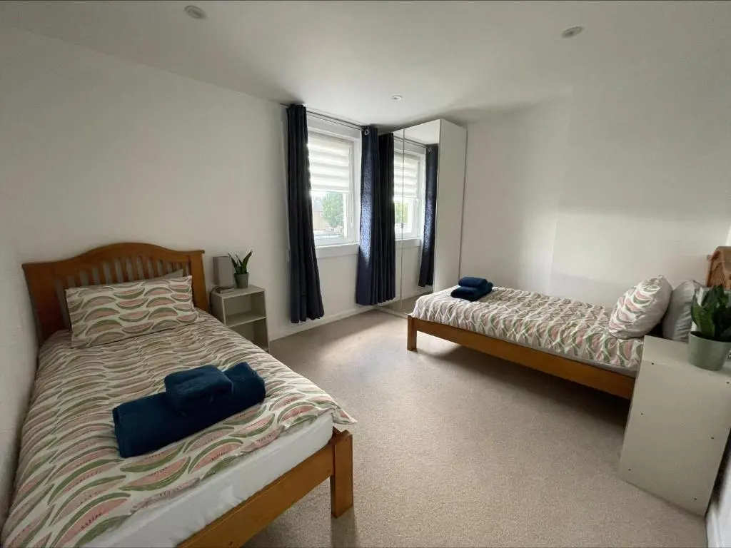 a bedroom with two beds and a window at Columba House in Inverness