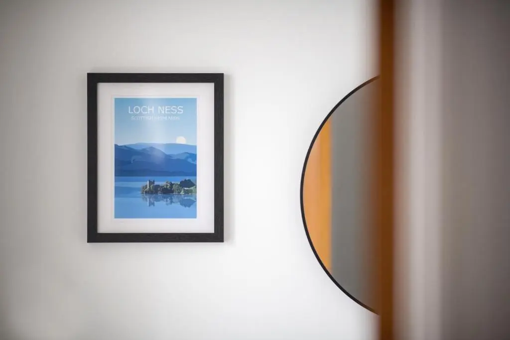 a framed picture on a wall with a mirror at End House Inverness in Inverness