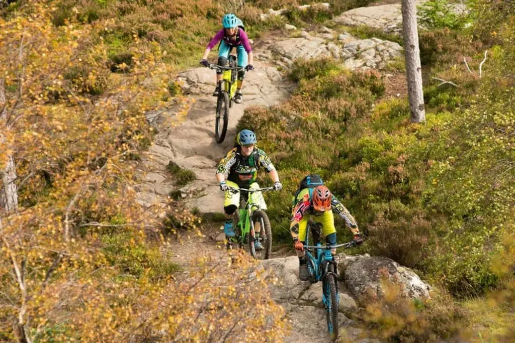 three people riding bikes down a rocky trail at *Cool, cosy cottage in the heart of the Highlands* in Kincraig