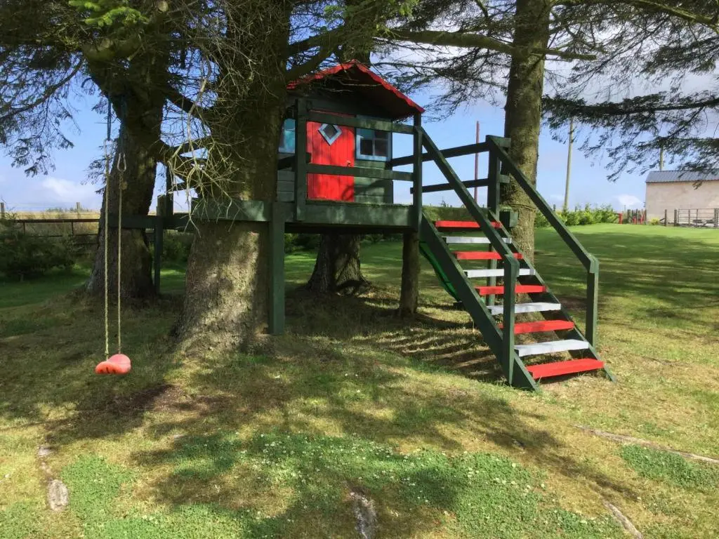 a tree house with a swing in a tree at Green Yurt with Hot Tub - Sleeps 3 Parking & Pets in Turriff
