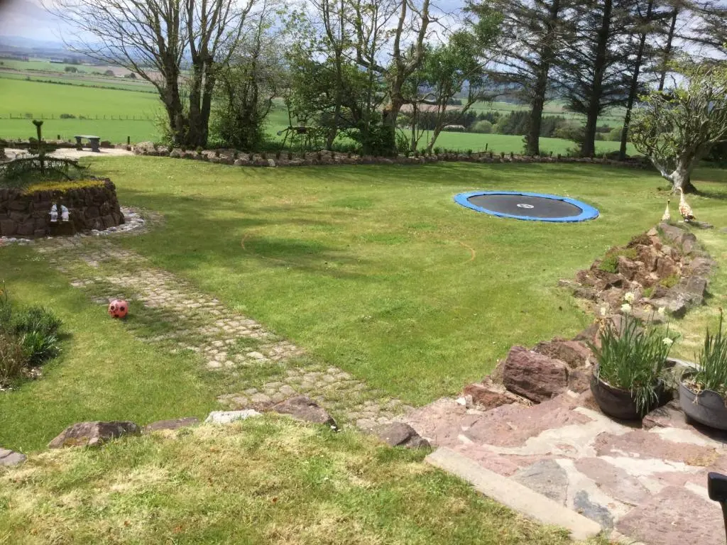 a person playing with a frisbee in a yard at Green Yurt with Hot Tub - Sleeps 3 Parking & Pets in Turriff