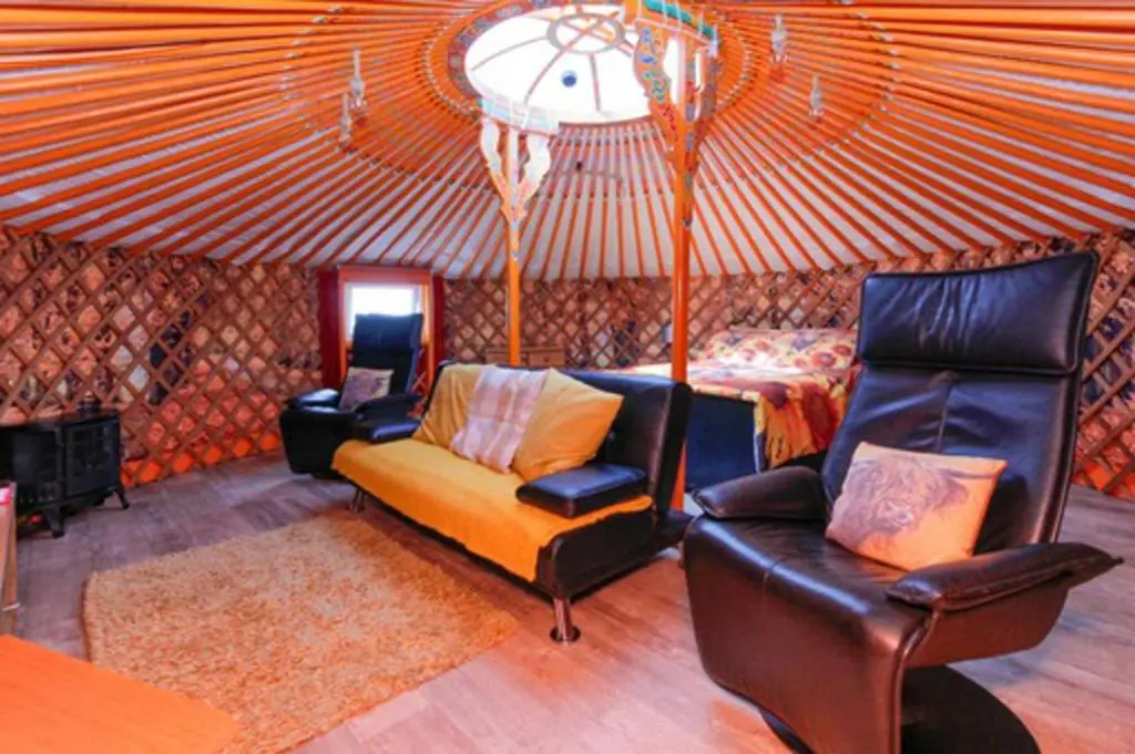 a living room with a couch and chairs and a bed at Orange Yurt with Hot Tub- Sleeps 3 Parking & Pets in Turriff