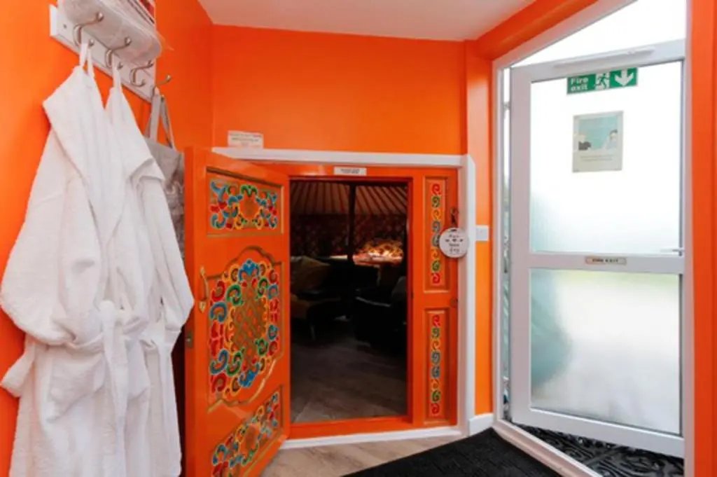 an orange room with an orange wall and a door at Orange Yurt with Hot Tub- Sleeps 3 Parking & Pets in Turriff