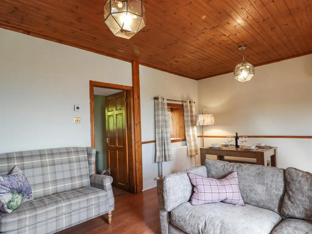 a living room with two couches and a wooden ceiling at Ceol na Mara in Berriedale