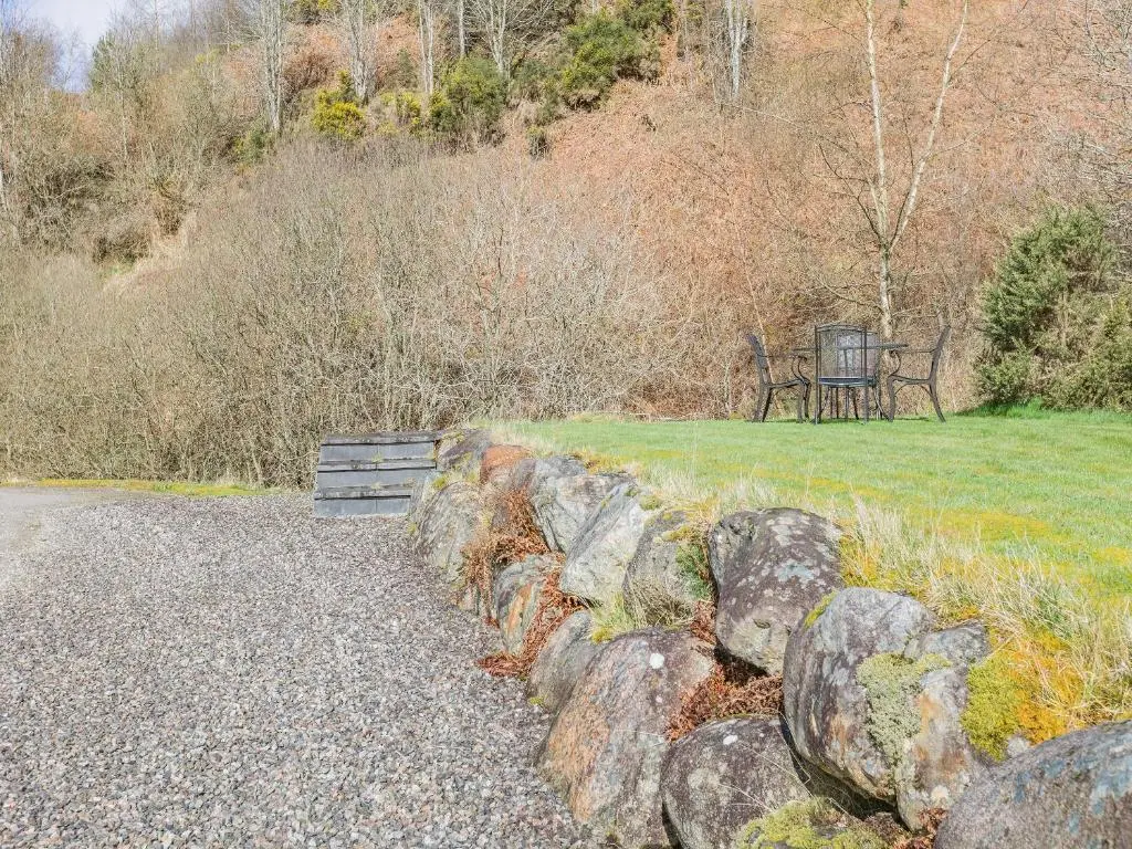 a park with a bench and a bunch of rocks at Allt Bronach - Ukc5763 in Laggan