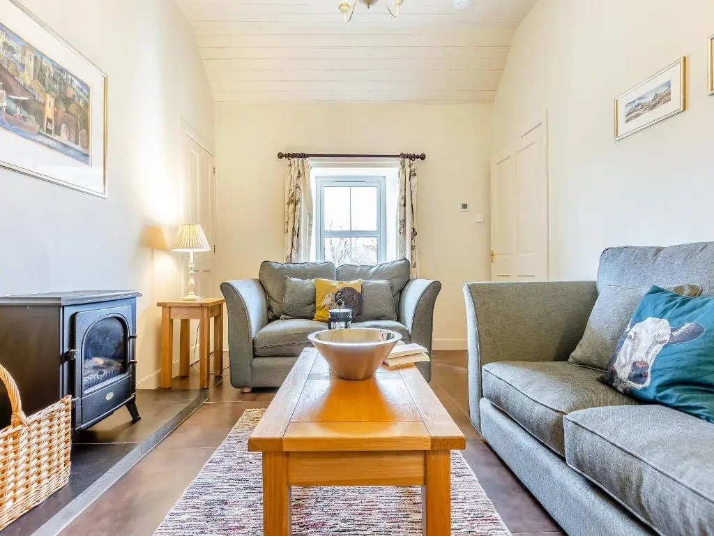 a living room with two couches and a fireplace at Allt Bronach - Ukc5763 in Laggan