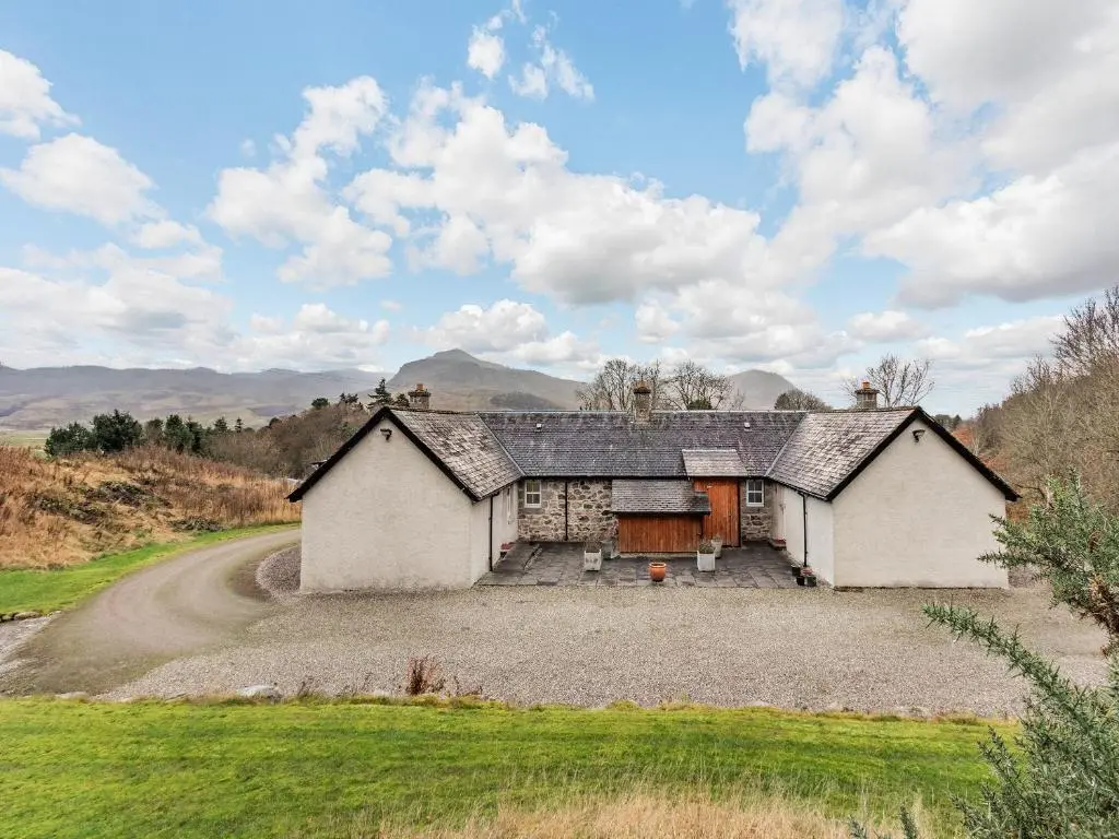 an old house on a gravel road at Allt Na Criche - Ukc5762 in Laggan