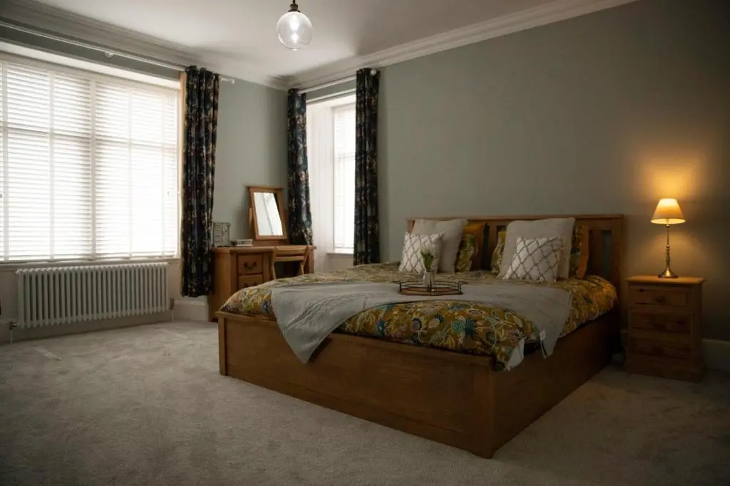a bedroom with a large bed and two windows at The old church house in Inverness