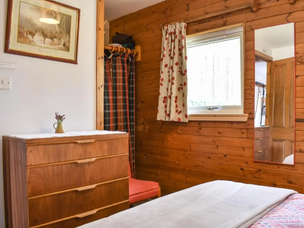 a bedroom with a bed and a window and a dresser at The Chalet - Ukc5786 in Nethy Bridge