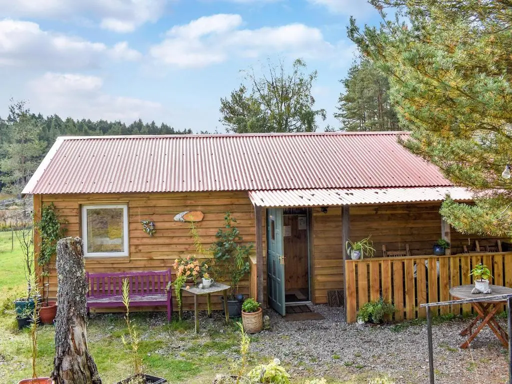 a small wooden cabin with a red roof at The Bothy - Ukc5785 in Nethy Bridge