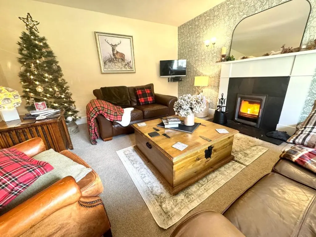a living room with a christmas tree and a fireplace at Rosemount Cottage TWO - Highland Cottage in Garve