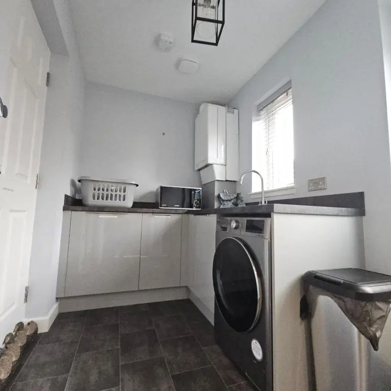 a small kitchen with a washing machine in it at The White House in Elgin