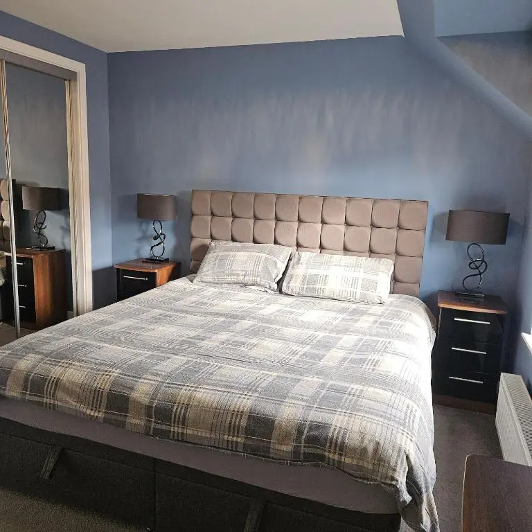 a bedroom with a large bed with two night stands at The White House in Elgin
