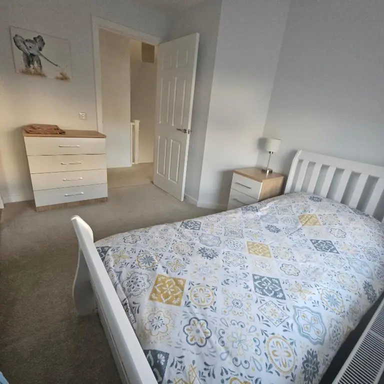 a bedroom with a bed with a blue and yellow quilt at The White House in Elgin