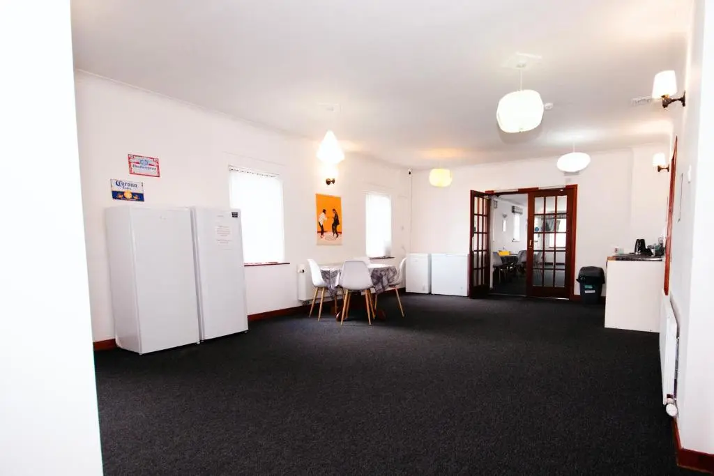 a room with white appliances and a table and chairs at Weston House Keith in Keith