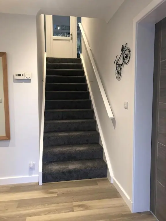 a staircase in a house with a bike on the wall at Foinaven House in Ullapool