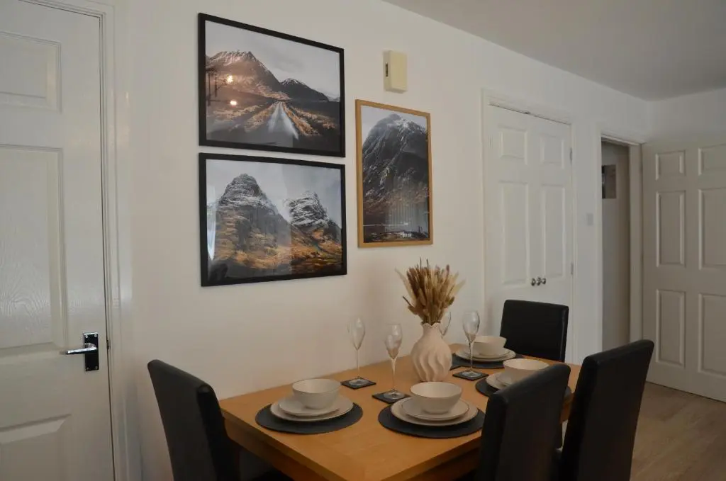 a dining room with a wooden table with chairs at SCOTTISH HIGHLANDS Superb 2 bedroom apartment. in Invergarry