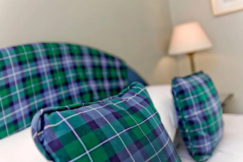 two green and purple plaid chairs with a lamp at Dalnaglar Castle in Blairgowrie