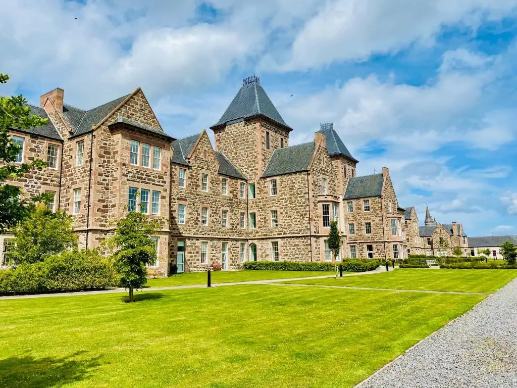 a large stone building with a green lawn at Great Glen Townhouse Inverness - Entire 3 Story Townhouse in Inverness