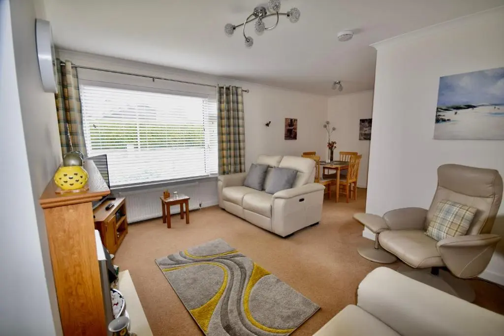 a living room with a couch and a chair at 'Edgewood' - spacious detached bungalow in Inverness